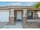 White front door entry with stone accents and small porch at 17475 W Caribbean Ln, Surprise, AZ 85388