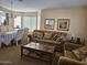 Living room with dining area, plush furniture, and large windows at 17475 W Caribbean Ln, Surprise, AZ 85388