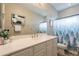 Well-lit bathroom featuring a white vanity, large mirror, and a shower with a decorative forest-themed curtain at 4353 E Santa Fe Ct, Gilbert, AZ 85297