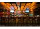 Long bar with many barstools and multiple screens at 602 E Taylor St, Tempe, AZ 85288
