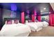 Large bedroom featuring three beds, neon lights, and pink curtains at 602 E Taylor St, Tempe, AZ 85288
