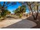 Spacious backyard with a flagstone patio, mature trees, and lush landscaping at 9048 E Cedar Waxwing Dr, Sun Lakes, AZ 85248