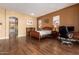 Comfortable bedroom with hardwood floors, a desk and views into another bathroom at 9048 E Cedar Waxwing Dr, Sun Lakes, AZ 85248