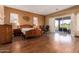 Spacious bedroom with wood flooring, a wooden bed frame and access to a patio at 9048 E Cedar Waxwing Dr, Sun Lakes, AZ 85248