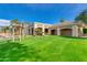 Clubhouse with a lush green lawn near a lake at 9048 E Cedar Waxwing Dr, Sun Lakes, AZ 85248