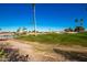 Green grass golf course with palm trees and a pond in the background at 9048 E Cedar Waxwing Dr, Sun Lakes, AZ 85248