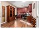 Spacious home office with built-in wooden cabinetry and hardwood floors at 9048 E Cedar Waxwing Dr, Sun Lakes, AZ 85248
