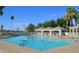Community pool with shaded seating and people enjoying the water at 9048 E Cedar Waxwing Dr, Sun Lakes, AZ 85248