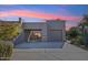 Front view of a contemporary home with a two-car garage and desert landscaping at 9250 E Whitethorn Cir, Scottsdale, AZ 85266