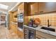 Kitchen with wood cabinets, granite counters, and wine cooler at 9250 E Whitethorn Cir, Scottsdale, AZ 85266