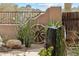 Stone water feature with plants and a wagon wheel in a desert landscape at 9250 E Whitethorn Cir, Scottsdale, AZ 85266