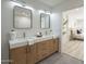 Bright bathroom features double sinks with quartz countertops, wood cabinets, and modern fixtures at 1323 W Tuckey Ln, Phoenix, AZ 85013