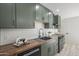 Updated kitchen features sage green cabinets, butcher block countertops, and modern appliances at 1323 W Tuckey Ln, Phoenix, AZ 85013