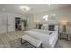 Light and airy main bedroom with a large bed, modern furniture, and a view into the bathroom at 1323 W Tuckey Ln, Phoenix, AZ 85013
