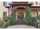 Elegant front entrance with a wooden door, lush greenery, and a covered porch at 2697 E Via Del Arboles --, Gilbert, AZ 85298
