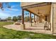 Large stone patio with covered seating area, fire pit, and grassy yard at 2697 E Via Del Arboles --, Gilbert, AZ 85298