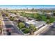 Aerial view of a neighborhood with homes, green spaces, and city skyline in the background at 1345 W Edgemont Ave, Phoenix, AZ 85007