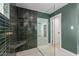 Modern shower with green tile, built-in bench, and glass enclosure create a luxurious and stylish bathroom space at 1345 W Edgemont Ave, Phoenix, AZ 85007