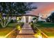 Charming home exterior with walkway, manicured lawn, modern door, and warm landscape lighting at 1345 W Edgemont Ave, Phoenix, AZ 85007