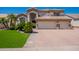 Two-story house with three car garage, landscaped lawn, and brick walkway at 1442 E Catamaran Dr, Gilbert, AZ 85234