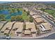 Aerial view of a community with houses, palm trees, a golf course and lake at 14426 W Morning Star Trl, Surprise, AZ 85374