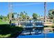 Picturesque wooden bridge over a calm lake, surrounded by palm trees at 14426 W Morning Star Trl, Surprise, AZ 85374