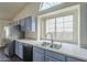 Kitchen with light blue cabinets, stainless steel appliances, and a double sink at 14426 W Morning Star Trl, Surprise, AZ 85374