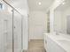 Bathroom features a glass enclosed shower, double sinks, tiled floors, and built-in shelving at 16023 W Desert Hollow Dr, Surprise, AZ 85387