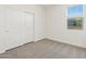 Bright bedroom with neutral carpet has a window and a closet for ample storage space at 16023 W Desert Hollow Dr, Surprise, AZ 85387