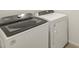 Well-lit laundry room features a white Whirlpool washer and dryer for convenient in-home laundry at 16023 W Desert Hollow Dr, Surprise, AZ 85387