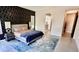 Modern bedroom with black accent wall, neutral colored bedding, bedside table and decorative lamps at 2835 E Los Gatos Dr, Phoenix, AZ 85050