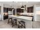 Modern kitchen featuring a large island with seating, stainless steel appliances, and dark cabinetry at 2835 E Los Gatos Dr, Phoenix, AZ 85050