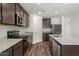 Modern kitchen showcasing stainless steel appliances, granite countertops, and an island with a sink, enhancing functionality at 4079 N Ghost Hollow Way, Casa Grande, AZ 85122
