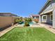 Resort-style backyard featuring a sparkling pool, artificial turf, and lush landscaping at 10559 E Simone Ave, Mesa, AZ 85212