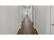 Long hallway with wood-look tile flooring and white walls leading to the rest of the house at 10559 E Simone Ave, Mesa, AZ 85212