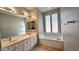 Bathroom with double vanity and soaking tub at 13613 W Cypress St, Goodyear, AZ 85395