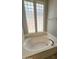 Oval bathtub with two windows offering natural light at 13613 W Cypress St, Goodyear, AZ 85395