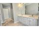 A Primary bathroom with double sinks, white cabinets and a walk-in shower at 13613 W Cypress St, Goodyear, AZ 85395