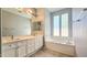 Bright Primary bathroom with double sinks, soaking tub and large mirrors at 13613 W Cypress St, Goodyear, AZ 85395