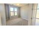 A bright bedroom with large windows, neutral carpet, and fresh gray paint at 13613 W Cypress St, Goodyear, AZ 85395