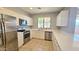 Bright kitchen features stainless steel appliances, white cabinets, and quartz countertops at 13613 W Cypress St, Goodyear, AZ 85395