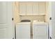Laundry room features a white washer and dryer with cabinets above at 13613 W Cypress St, Goodyear, AZ 85395