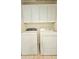 Laundry room features a white washer and dryer with cabinets above at 13613 W Cypress St, Goodyear, AZ 85395