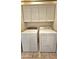 Laundry room with washer and dryer and overhead cabinets at 13613 W Cypress St, Goodyear, AZ 85395