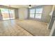 Open living room featuring a mix of tile and carpet flooring, with a sliding glass door to the backyard at 13613 W Cypress St, Goodyear, AZ 85395
