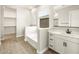 Bathroom featuring white cabinets, dual sinks, tub, and a walk-in closet at 17648 W Pierson St, Goodyear, AZ 85395