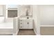 Bright bathroom featuring white cabinets and dual sinks and a large tub at 17648 W Pierson St, Goodyear, AZ 85395
