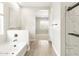 Bright bathroom featuring a tub, separate shower, and wood look tile flooring at 17648 W Pierson St, Goodyear, AZ 85395