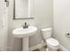 Cozy bathroom with pedestal sink, toilet, and light neutral paint at 17648 W Pierson St, Goodyear, AZ 85395