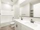 Bathroom featuring dual sinks, white cabinets, and a tub with white tile surround at 17648 W Pierson St, Goodyear, AZ 85395